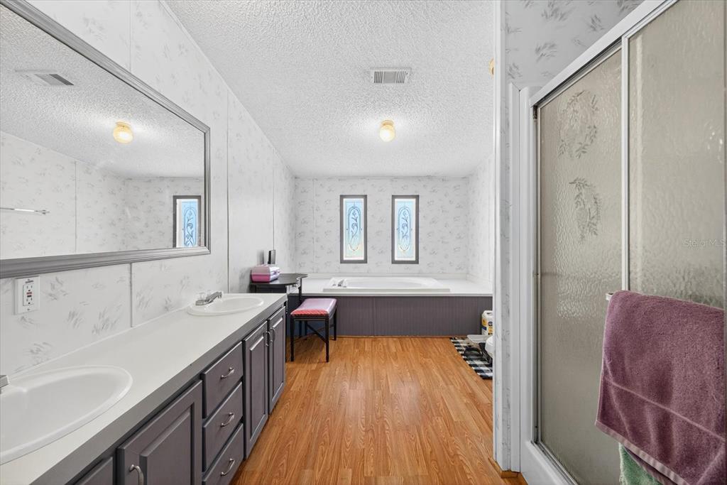 5280 Golddust Road Spring Hill, FL 34609 - Photo 23 of 41 a spacious bathroom with a tub double vanity sink and a mirror