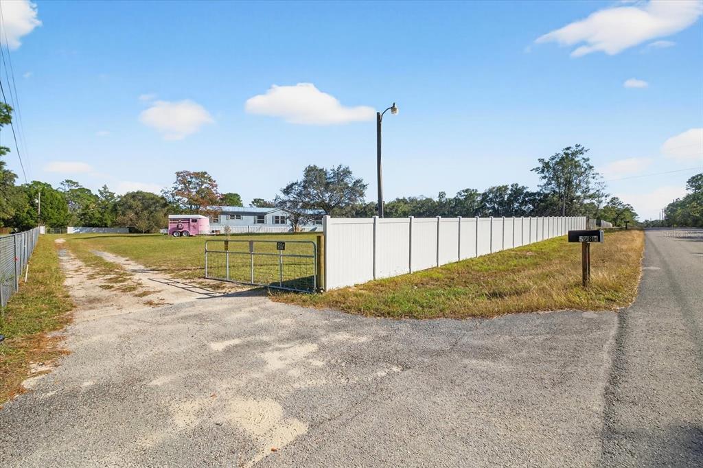 5280 Golddust Road Spring Hill, FL 34609 - Photo 35 of 41 a view of a swimming pool with a lake and trees in the background