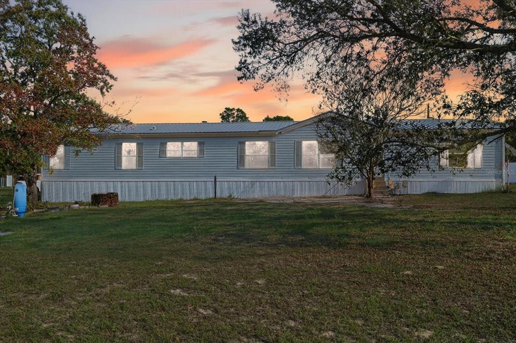 5280 Golddust Road Spring Hill, FL 34609 - Photo 41 of 41 a brick house next to a yard with a large tree