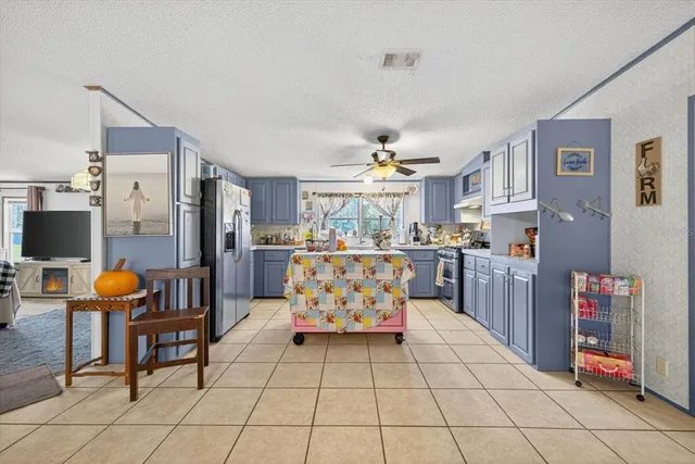 a kitchen with stainless steel appliances kitchen island granite countertop a refrigerator and cabinets