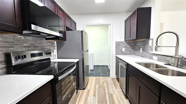 a kitchen with a sink stove and refrigerator