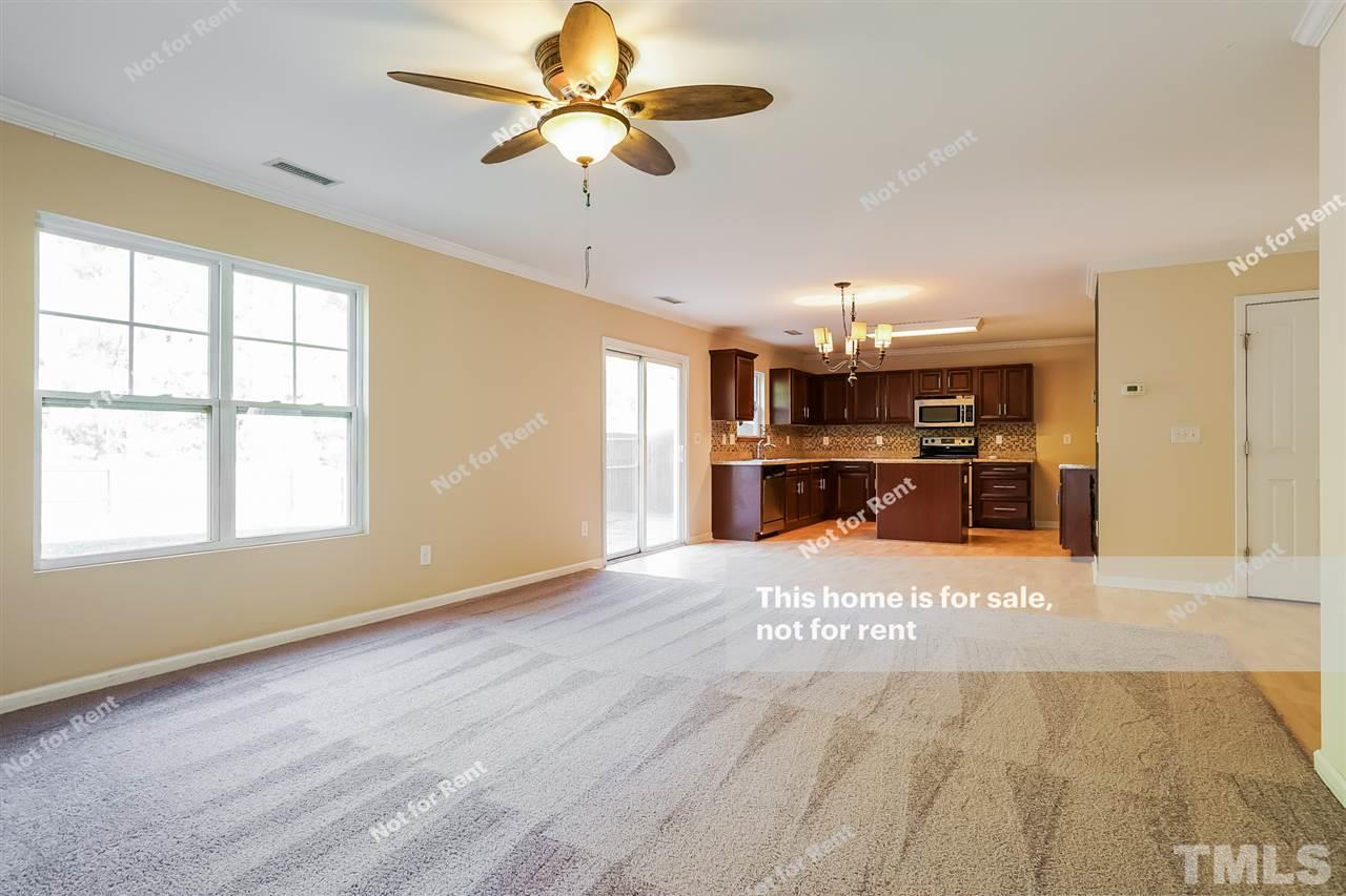 4439 Stonewall Drive Raleigh, NC 27604 - Photo 13 of 27 a view of an empty room with a window and a kitchen