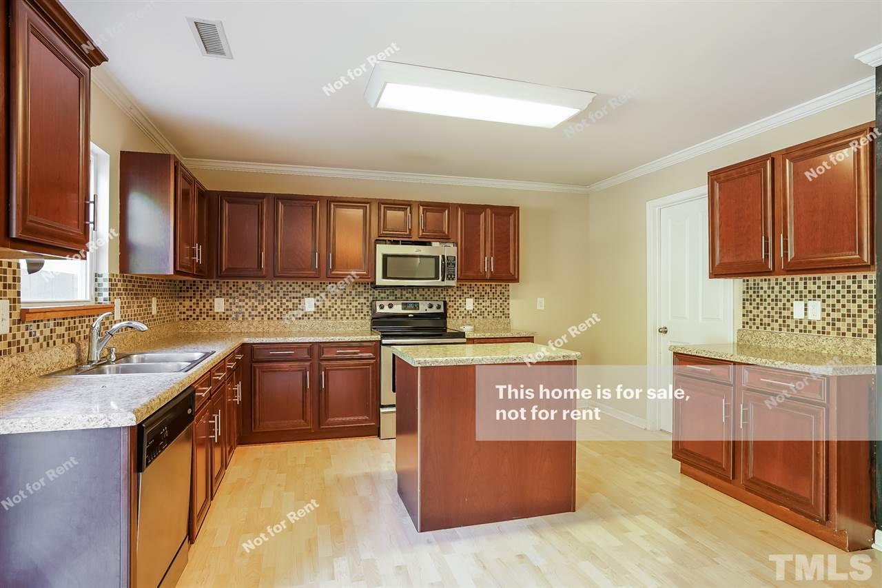 4439 Stonewall Drive Raleigh, NC 27604 - Photo 4 of 27 a large kitchen with stainless steel appliances granite countertop a stove a sink dishwasher and a microwave oven with cabinets