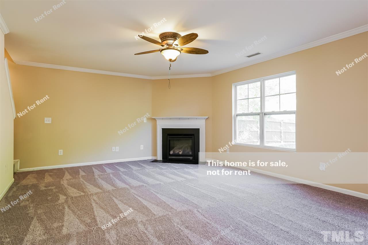 4439 Stonewall Drive Raleigh, NC 27604 - Photo 5 of 27 an empty room with windows and fireplace