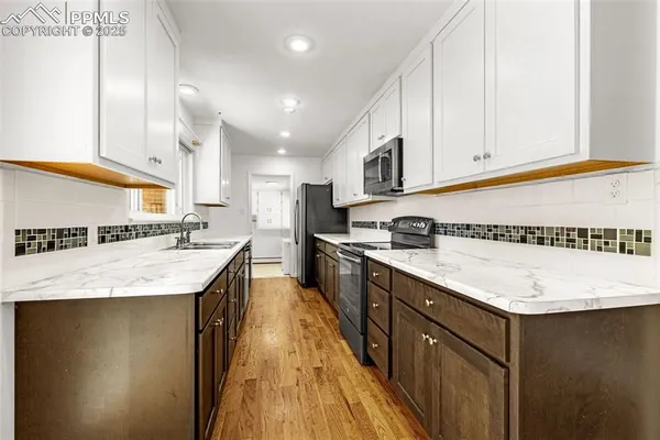 a kitchen with a sink a stove and cabinets