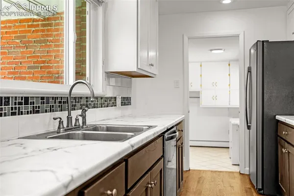 a kitchen with stainless steel appliances granite countertop a sink and a refrigerator