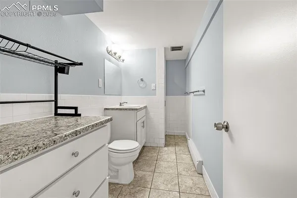 a bathroom with a granite countertop sink a toilet and shower