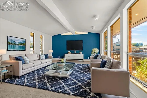 a living room with furniture large window and a flat screen tv