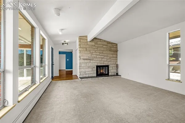a view of an empty room with a fireplace and a window