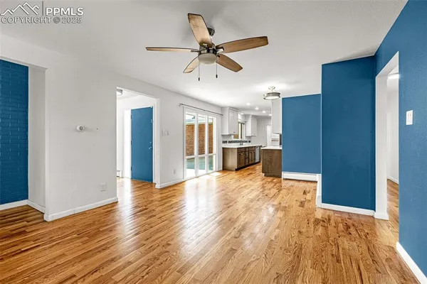 a view of a livingroom with wooden floor and a ceiling fan
