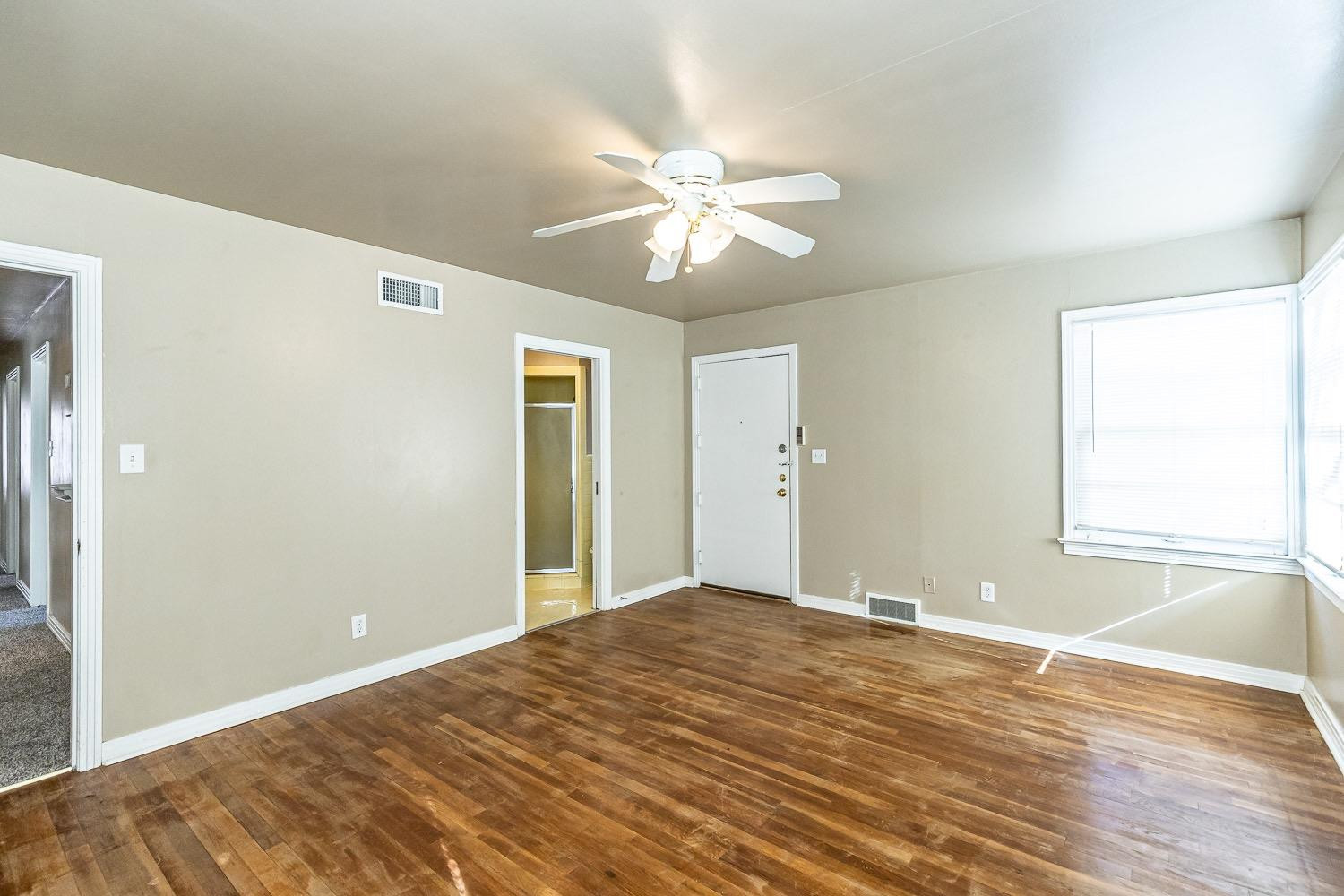 3708 27th Street Lubbock, TX 79410 - Photo 13 of 23 a view of an empty room with window and wooden floor