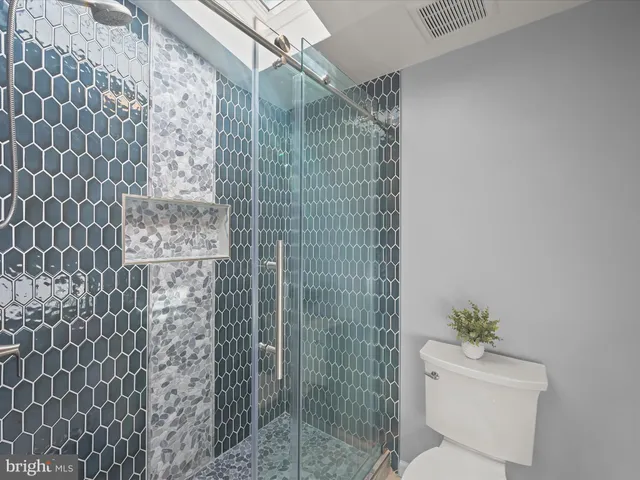 an aerial view of a city with lots of residential buildings ocean and mountain view in back