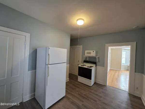 a kitchen with a refrigerator and a stove top oven