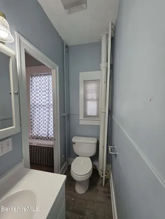 a bathroom with a toilet a sink and a window