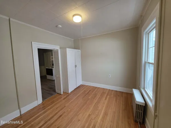a view of a room with wooden floor and a window