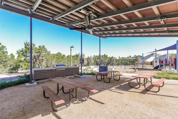 a view of a patio with a table chairs and a barbeque