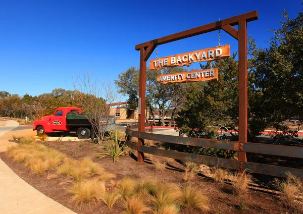 a backyard of a house with barbeque oven table and chairs