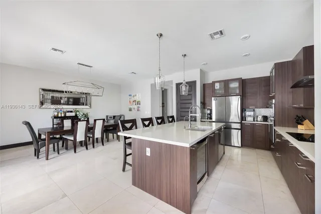 a large kitchen with lots of counter space a sink appliances and dining table