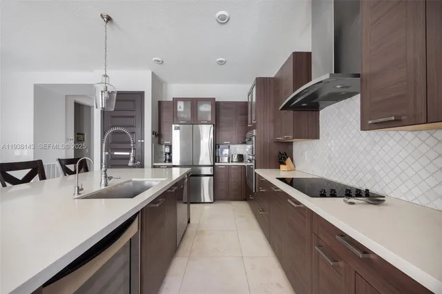 a large kitchen with a kitchen island a sink stainless steel appliances and cabinets