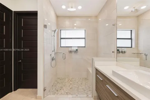 a bathroom with a shower sink and mirror