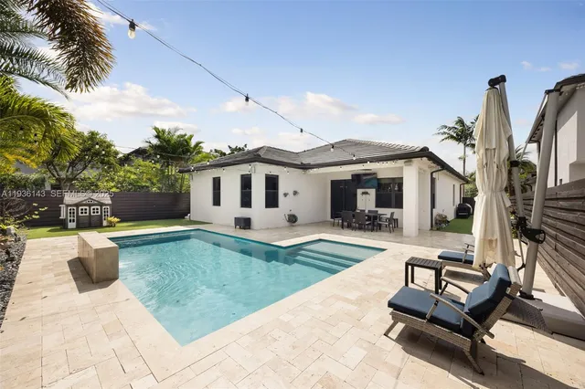 a view of a house with backyard and sitting area