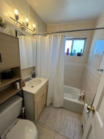 a bathroom with a sink a toilet a mirror and shower