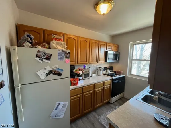 a kitchen with stainless steel appliances granite countertop a refrigerator sink and wooden cabinets