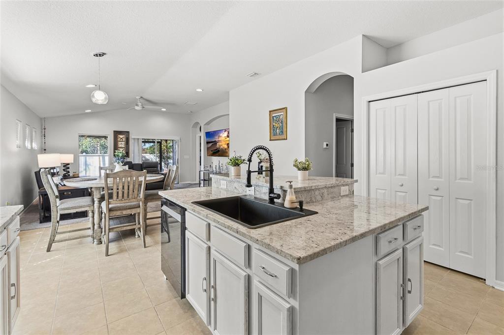 6641 Boulder Run Loop Wesley Chapel, FL 33545 - Photo 13 of 43 a kitchen with kitchen island a sink table and chairs