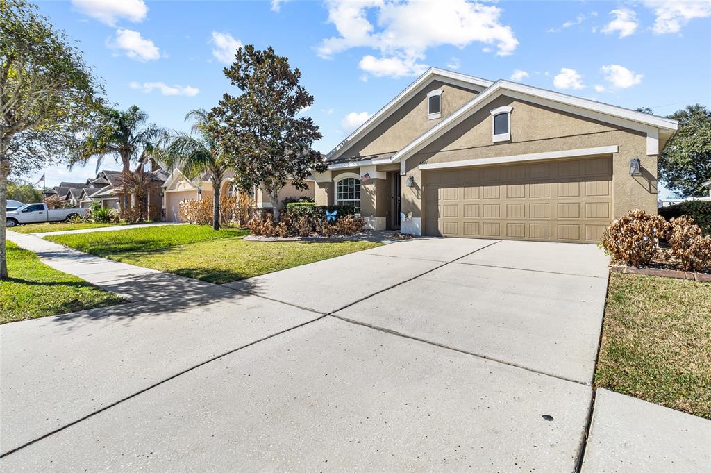 6641 Boulder Run Loop Wesley Chapel, FL 33545 - Photo 2 of 43 a front view of a house with a yard and garage