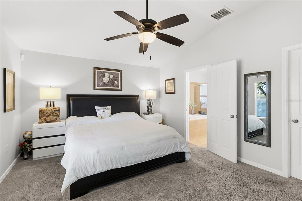 6641 Boulder Run Loop Wesley Chapel, FL 33545 - Photo 21 of 43 a bedroom with a large bed and a ceiling fan