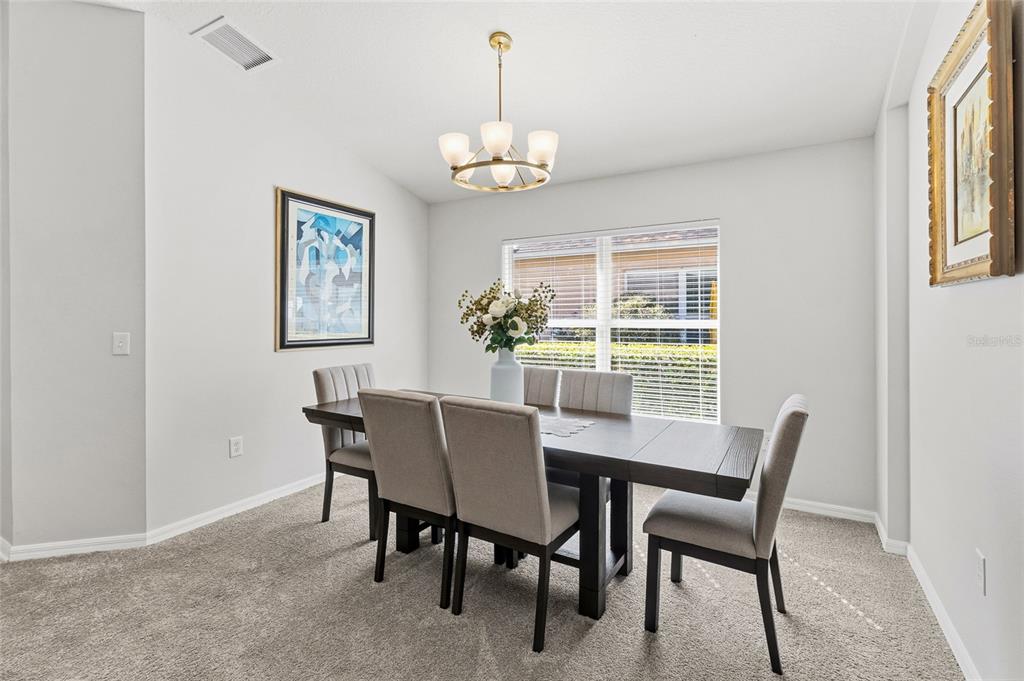 6641 Boulder Run Loop Wesley Chapel, FL 33545 - Photo 7 of 43 a dining room with furniture a chandelier and a window