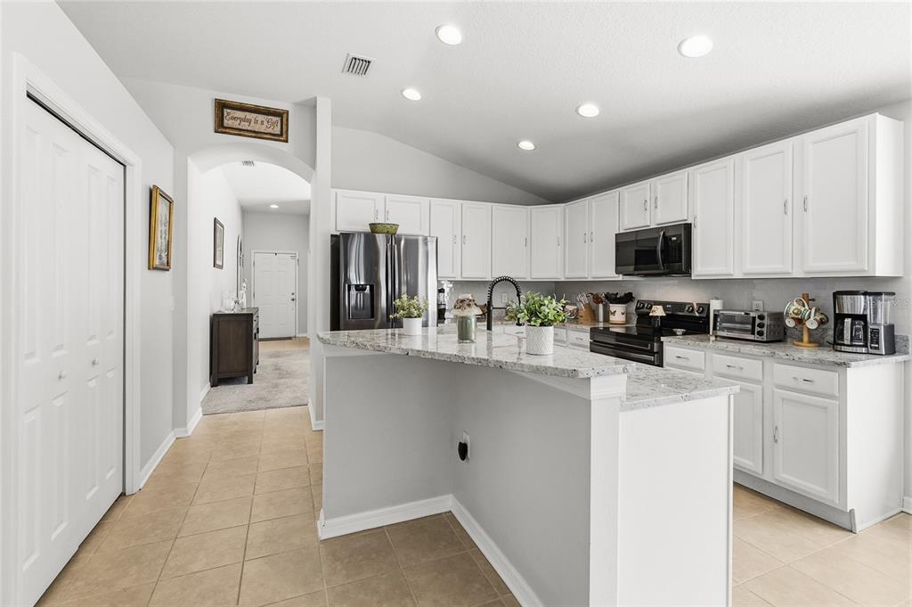 6641 Boulder Run Loop Wesley Chapel, FL 33545 - Photo 9 of 43 a kitchen with stainless steel appliances a refrigerator sink stove and microwave