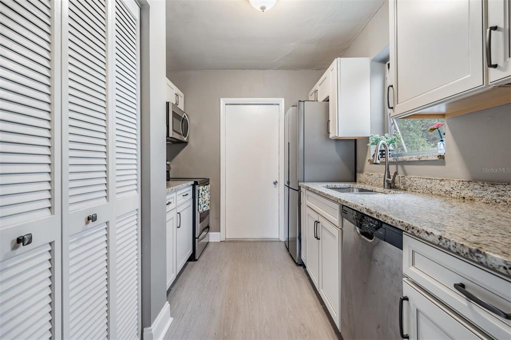 6985 Merrick Lane Spring Hill, FL 34606 - Photo 10 of 15 a kitchen with granite countertop a sink and a refrigerator