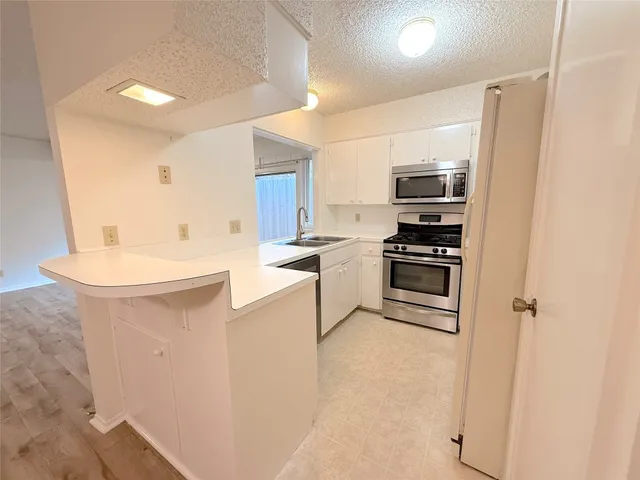 a kitchen with kitchen island a sink stainless steel appliances and cabinets
