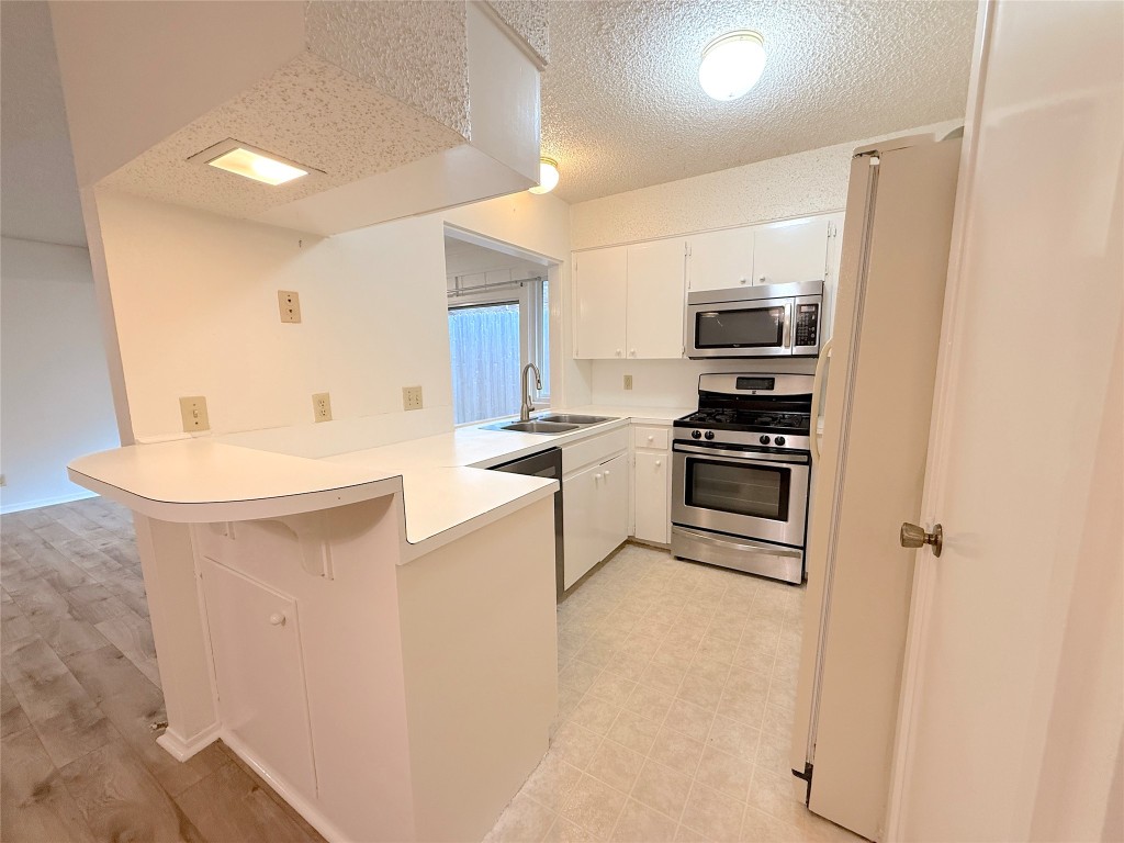 3607 Summit Bend, Unit B Austin, TX 78759 - Photo 12 of 24 a kitchen with kitchen island a sink stainless steel appliances and cabinets