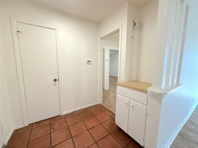 a view of a utility room with closet and mirror