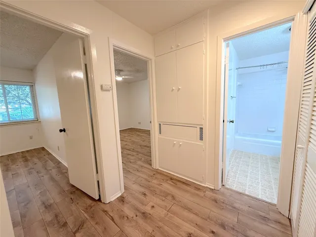 an empty room with wooden floor and a bathroom