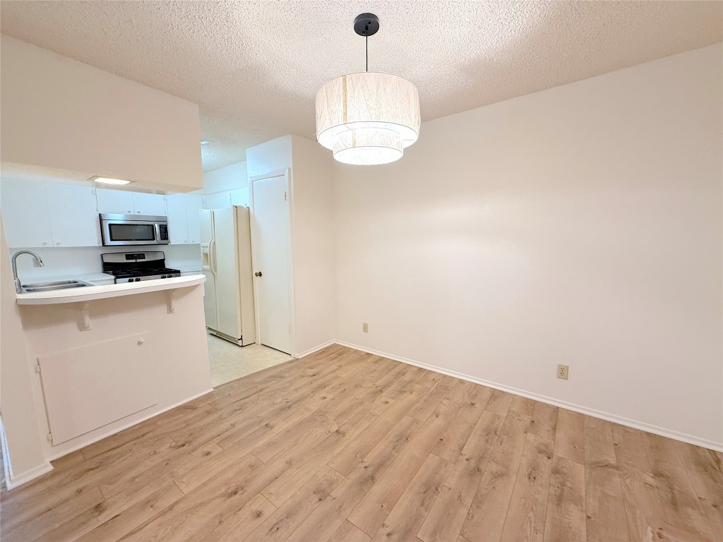 3607 Summit Bend, Unit B Austin, TX 78759 - Photo 7 of 24 a kitchen with cabinets and wooden floor