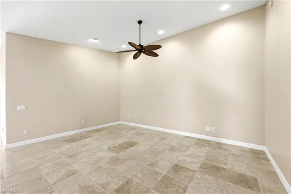an empty room with a ceiling fan and carpet