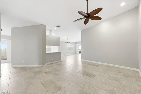 a view of an empty room and kitchen view