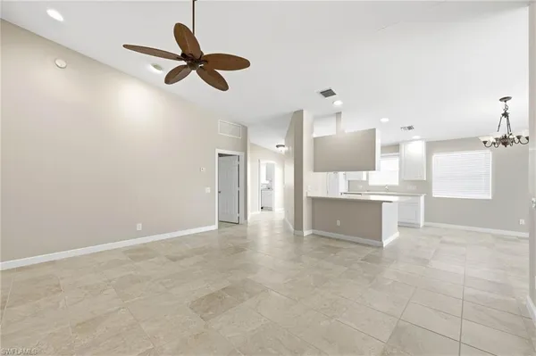 a view of an empty room and kitchen view