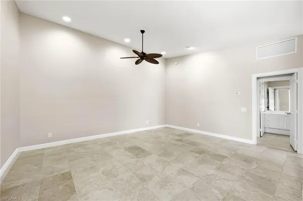 an empty room with a ceiling fan and window