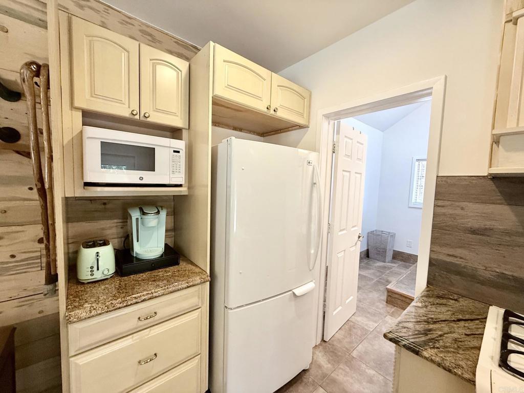 22292 Crestline Road Palomar Mountain, CA 92060 - Photo 31 of 38 a kitchen with a refrigerator and cabinets