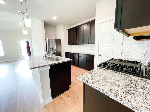 a kitchen with a sink stove and refrigerator