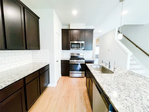 a kitchen with granite countertop stainless steel appliances and wooden cabinets