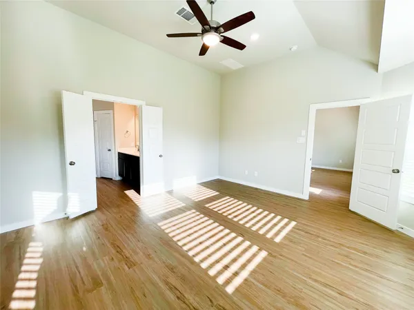 a view of a room with wooden floor and a ceiling fan