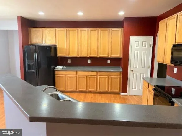 a view of kitchen with stainless steel appliances granite countertop a refrigerator a stove a sink a dining table and chair with wooden floor