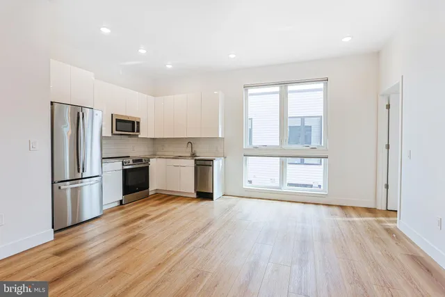 a kitchen with wooden floors and stainless steel appliances