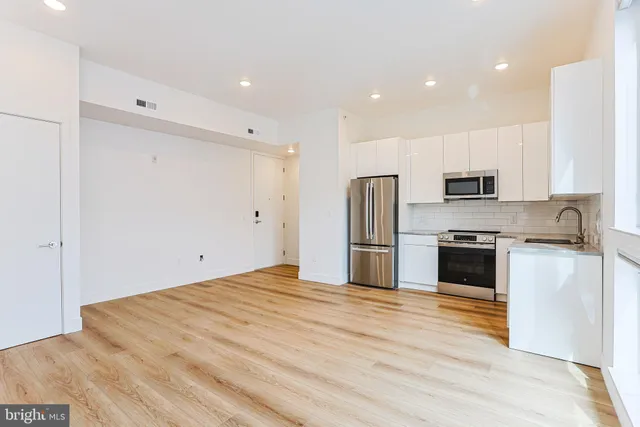 a kitchen with stainless steel appliances a refrigerator and a stove top oven