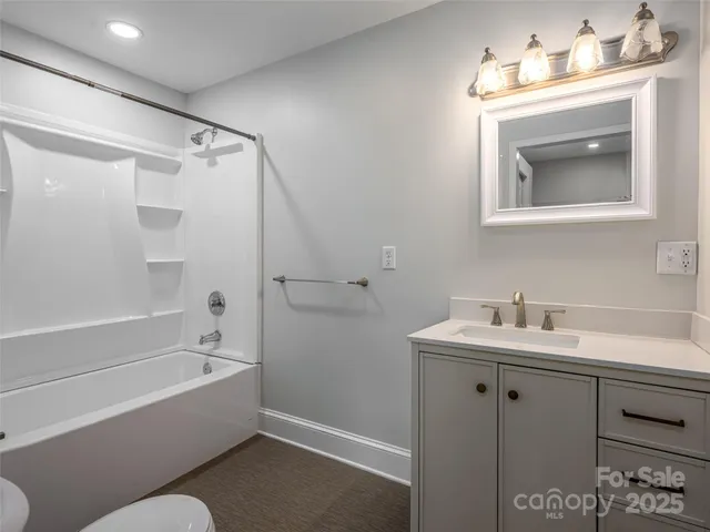a bathroom with a bathtub sink vanity and mirror